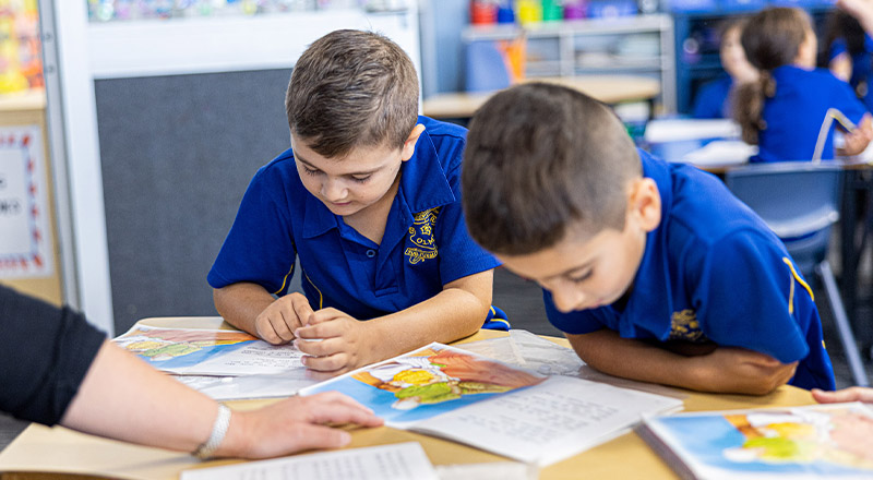 Teacher reading with students in the library at Our Lady of Mount Carmel Primary School Wentworthville