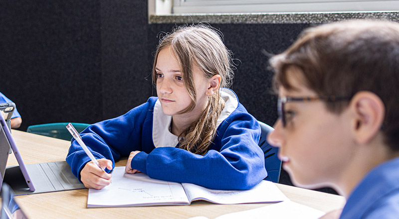 Student studying at her desk in the classroom at Our Lady of Mount Carmel Primary School Wentworthville