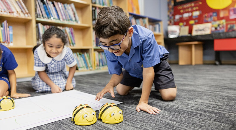 Students programming bee bots in the library at Our Lady of Mount Carmel Primary School Wentworthville