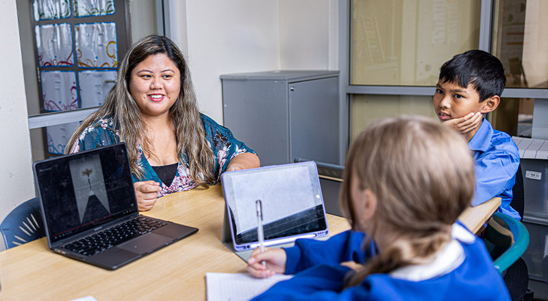 Teacher with students learning at Our Lady of Mount Carmel Primary School Wentworthville